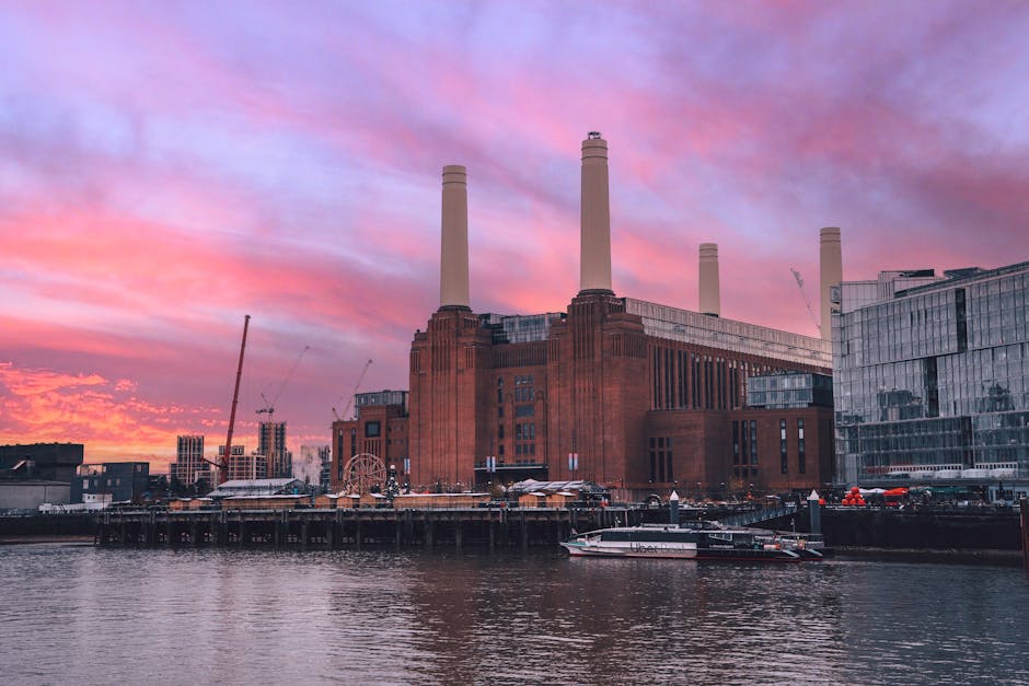 A close-up view of the exterior of the Battersea Power Station, featuring its brickwork facade with a textured surface and vertical windows. The building's structure is seen from a low angle, emphasiz